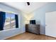 Cozy bedroom features a window with blue curtains, light blue walls, and a wood dresser with a TV at 860 N Mcqueen Rd # 1058, Chandler, AZ 85225