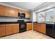 Well-equipped kitchen featuring wooden cabinets, black appliances and tiled flooring at 860 N Mcqueen Rd # 1058, Chandler, AZ 85225