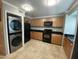 Modern kitchen featuring wood cabinets, black appliances, and tile flooring for a sleek cooking space at 860 N Mcqueen Rd # 1058, Chandler, AZ 85225