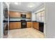 Bright kitchen with wooden cabinets, black appliances, and included washer-dryer at 860 N Mcqueen Rd # 1058, Chandler, AZ 85225