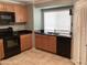Well-lit kitchen with black appliances, tile flooring and light wood cabinetry at 860 N Mcqueen Rd # 1058, Chandler, AZ 85225