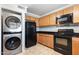 Contemporary kitchen equipped with sleek appliances, wooden cabinets, and washer-dryer combo at 860 N Mcqueen Rd # 1058, Chandler, AZ 85225