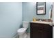 Cozy half bathroom featuring a modern vanity, mirror, toilet and blue-painted walls at 860 N Mcqueen Rd # 1058, Chandler, AZ 85225