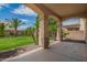 Covered back patio overlooking a spacious lawn with mature trees and desert landscaping at 881 E Boston St, Gilbert, AZ 85295