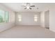 Bright, carpeted bedroom with large window, ceiling fan and neutral color scheme at 881 E Boston St, Gilbert, AZ 85295
