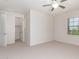 An airy bedroom featuring neutral carpet, a ceiling fan, and a walk-in closet at 881 E Boston St, Gilbert, AZ 85295