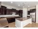 Modern kitchen with dark wood cabinets, stainless steel appliances, and a granite-topped island at 881 E Boston St, Gilbert, AZ 85295