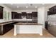 Modern kitchen with dark wood cabinets, stainless steel appliances, and a granite-topped island at 881 E Boston St, Gilbert, AZ 85295