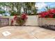 Enclosed backyard with concrete patio, surrounded by flowering bougainvillea plants at 9430 S 47Th Pl, Phoenix, AZ 85044