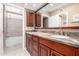 Bathroom with granite countertops, wooden cabinetry, and bathtub with grey tile at 9430 S 47Th Pl, Phoenix, AZ 85044
