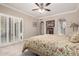 Bedroom with a ceiling fan, shuttered doors, and ensuite bathroom at 9430 S 47Th Pl, Phoenix, AZ 85044