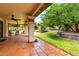 A covered patio with tile flooring, pillars, outdoor seating, and a green landscaped backyard at 9430 S 47Th Pl, Phoenix, AZ 85044