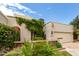 Beautiful exterior of home featuring lush greenery, an attached garage, and a desert landscape at 9430 S 47Th Pl, Phoenix, AZ 85044