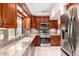 Well-lit kitchen with wooden cabinets, granite countertops, and stainless steel appliances at 9430 S 47Th Pl, Phoenix, AZ 85044