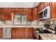 Kitchen featuring stainless steel appliances, wooden cabinets, and granite countertops at 9430 S 47Th Pl, Phoenix, AZ 85044