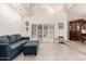 Bright living room with tiled floors, comfortable blue seating, and a wall of windows with white shutters at 9430 S 47Th Pl, Phoenix, AZ 85044