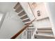 Carpeted staircase with white decorative railing, wooden handrail, and pendant lighting at 9430 S 47Th Pl, Phoenix, AZ 85044
