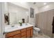 Bathroom with dual sinks, wood cabinets, and shower with curtain at 11626 E Yeager Cyn, Gold Canyon, AZ 85118
