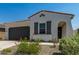 A single-Gathering home boasts a tile roof, dark gray shutters, and an attached two-car garage at 11626 E Yeager Cyn, Gold Canyon, AZ 85118