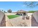 Lovely backyard with artificial grass, seating areas, and a covered patio for entertaining at 13443 W Post Dr, Surprise, AZ 85374