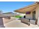 Inviting backyard with a covered patio, outdoor seating, and well-manicured grass at 13443 W Post Dr, Surprise, AZ 85374