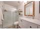 Charming bathroom featuring a glass shower, marble countertop and decorative mirror at 13443 W Post Dr, Surprise, AZ 85374