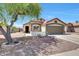 Charming single-story home with a well-manicured yard, desert landscaping, and cozy front porch at 13443 W Post Dr, Surprise, AZ 85374