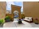 Private courtyard with comfortable seating area, an arched entry, and a tranquil garden space at 1367 S Country Club Dr # 1320, Mesa, AZ 85210
