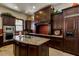 Gourmet kitchen featuring dark wood cabinetry, granite counters, mosaic backsplash, and tile floors at 1367 S Country Club Dr # 1320, Mesa, AZ 85210