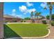 Lush backyard with artificial grass, gravel landscaping, mature trees, and privacy wall at 1526 E Glacier Pl, Chandler, AZ 85249
