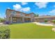 Backyard view showcasing synthetic grass, a covered patio, a pool, and the exterior of the home at 1526 E Glacier Pl, Chandler, AZ 85249