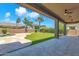 Inviting backyard features a covered patio, artificial grass, pavers, and mature palm trees at 1526 E Glacier Pl, Chandler, AZ 85249