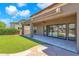 Outdoor living space with artificial grass, covered patio, and sliding glass doors at 1526 E Glacier Pl, Chandler, AZ 85249