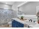 Bathroom featuring double sinks with backlit mirrors, blue vanity, and decorative shower curtain at 1526 E Glacier Pl, Chandler, AZ 85249