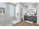 Bright bathroom with glass enclosed shower with stone floor, framed mirror, and gray vanity at 1526 E Glacier Pl, Chandler, AZ 85249