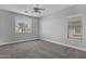 Spacious bedroom featuring soft gray carpet, a ceiling fan, and well-lit windows at 1526 E Glacier Pl, Chandler, AZ 85249