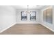 Dining area showcases modern light fixture, natural light from the window, and sleek floors, complemented by abstract artwork at 1526 E Glacier Pl, Chandler, AZ 85249