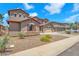 Two-story home featuring a three car garage, neutral stucco and stone accents with professionally landscaped front yard at 1526 E Glacier Pl, Chandler, AZ 85249