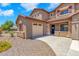 Two-story home featuring a two car garage, neutral stucco and stone accents with professionally landscaped front yard at 1526 E Glacier Pl, Chandler, AZ 85249