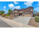 Two-story home featuring a three car garage, neutral stucco and stone accents with professionally landscaped front yard at 1526 E Glacier Pl, Chandler, AZ 85249