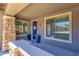 Inviting front porch with a bright blue door, white floral wreath and two potted plants at 1526 E Glacier Pl, Chandler, AZ 85249