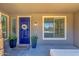 Inviting front porch with a bright blue door, white floral wreath and two potted plants at 1526 E Glacier Pl, Chandler, AZ 85249
