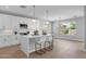 Modern white kitchen features a central island with seating and pendant lighting, and stainless steel appliances at 1526 E Glacier Pl, Chandler, AZ 85249