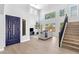 Bright living room features a high ceiling, light wood floors, comfortable seating area, and a striking blue front door at 1526 E Glacier Pl, Chandler, AZ 85249
