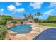 Backyard swimming pool with rock waterfall feature, surrounding stone, and lush landscaping at 1526 E Glacier Pl, Chandler, AZ 85249
