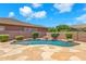 Relaxing backyard featuring a pool with a small waterfall feature, mature landscaping, and privacy fence at 1526 E Glacier Pl, Chandler, AZ 85249