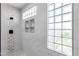 Modern shower features tile surround, built-in shelves, and glass block window at 1526 E Glacier Pl, Chandler, AZ 85249