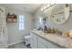 Bright bathroom featuring dual sinks with granite counters and round mirrors at 156 N Hawes Rd # 68, Mesa, AZ 85207