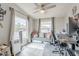 Cozy living room featuring a ceiling fan, bright windows, and comfortable gray furnishings with stylish accent pillows at 156 N Hawes Rd # 68, Mesa, AZ 85207