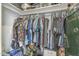 Messy walk-in closet with built-in shelving and a clothes rack at 156 N Hawes Rd # 68, Mesa, AZ 85207